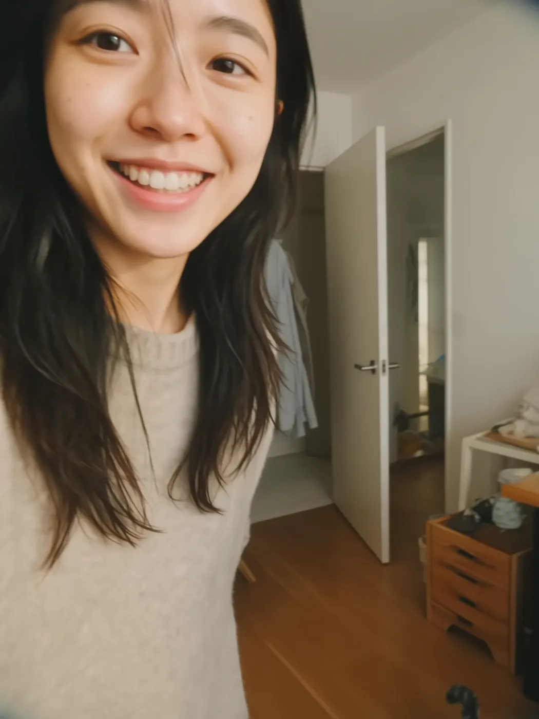 Smiling at the camera in a grey sweatshirt